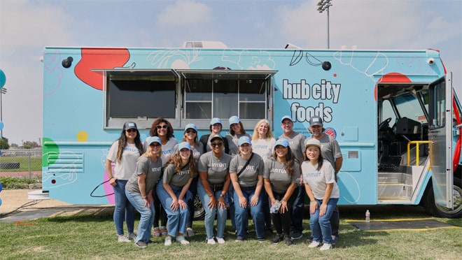 A group of people standing next to a food truck.