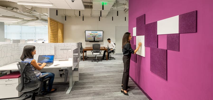 A person is standing in a room with a computer.