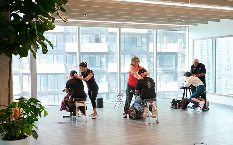 A group of people sitting around a table with a laptop.