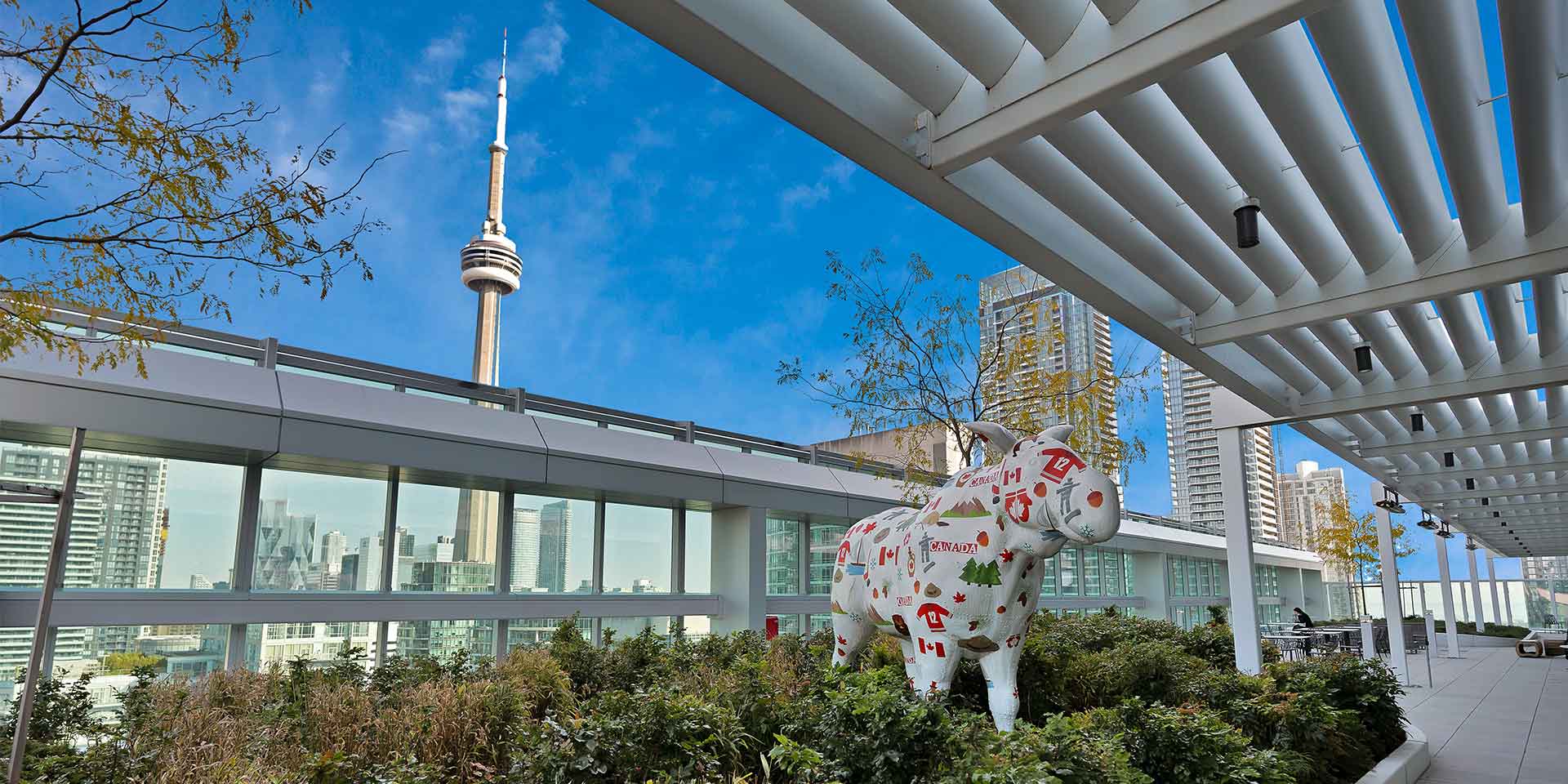 A large white dog standing next to a tall building.