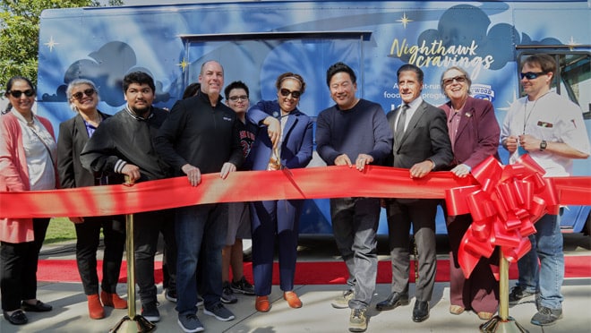 A group of people standing next to each other near a sign.