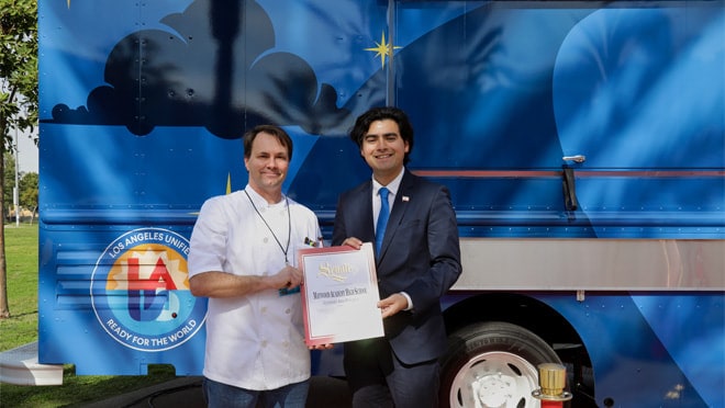 Two people standing in front of a truck.