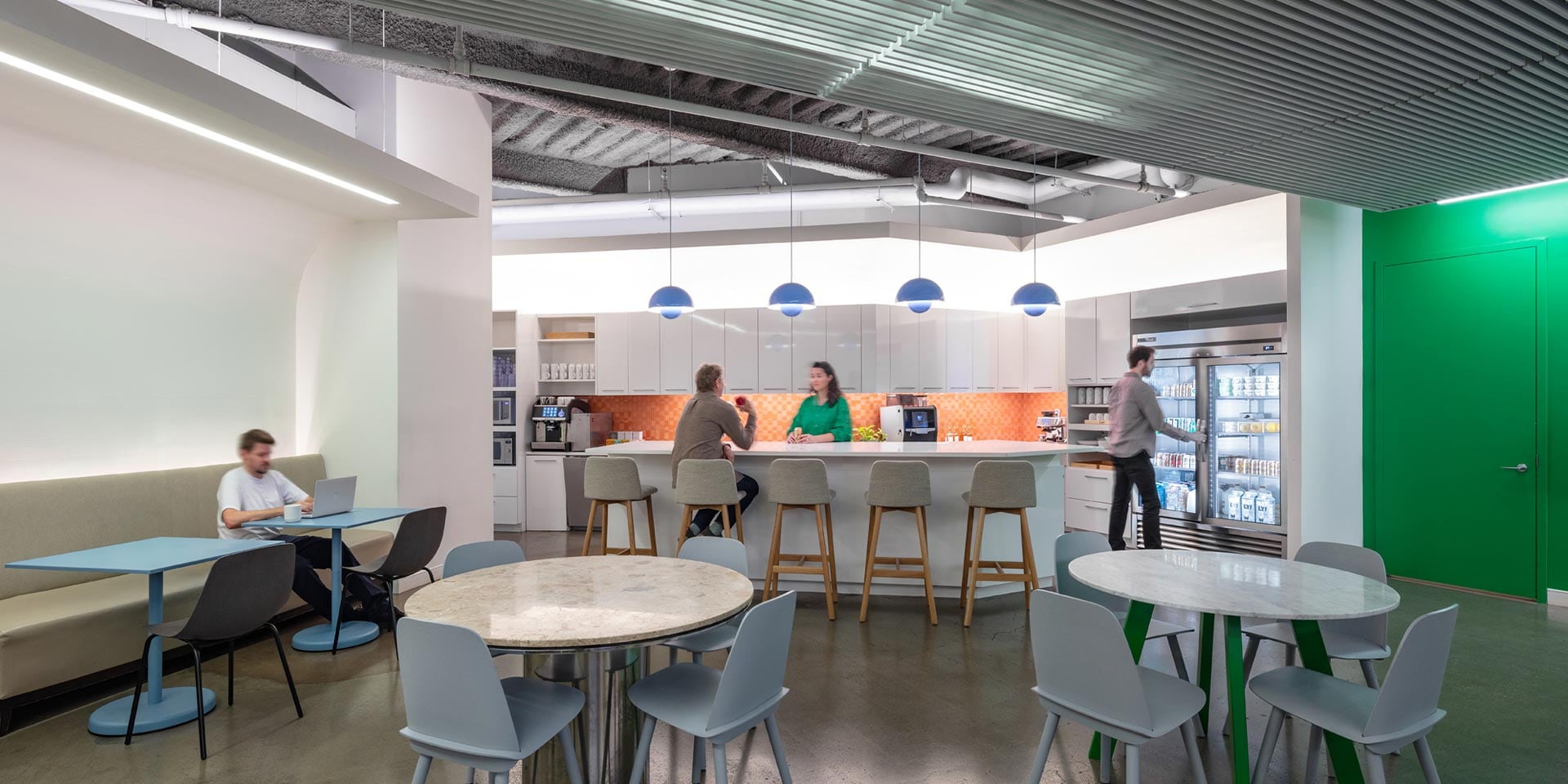 Two people are working in a kitchen with a table.